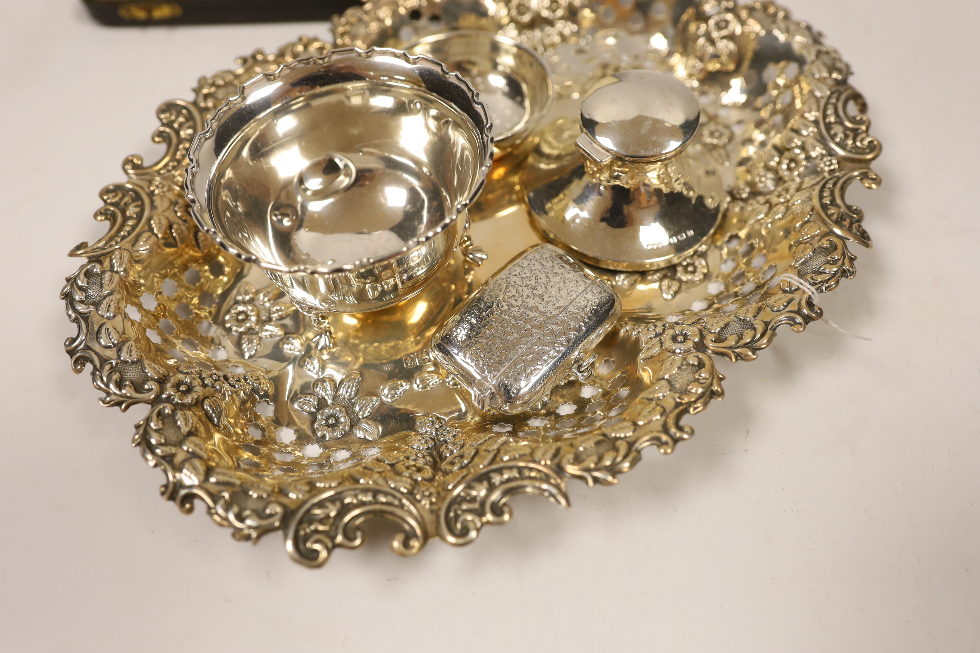 A George V pierced silver oval dish, London, 1914, 26.4cm, together with a small silver bowl, silver mounted inkstand, silver vesta case, silver tea strainer and a cased set of plated pastry forks.